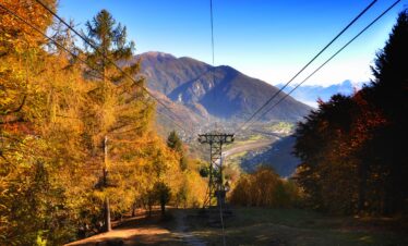 A beautiful shot of a stainless steel cable wire with a tall mountain and a clear blue sky in the background