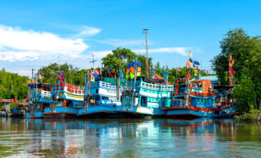 A grand white church with twin spires, palm trees, and a clear blue sky in the background.